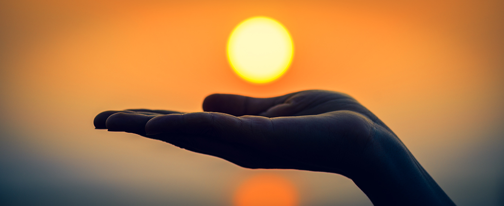 Close up and Silhouette of hand holding sun. Sun on woman hand.
